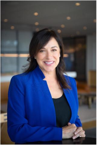 Smiling professional woman in blue jacket. 